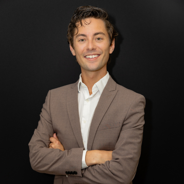 Smiling man in brown suit, arms crossed